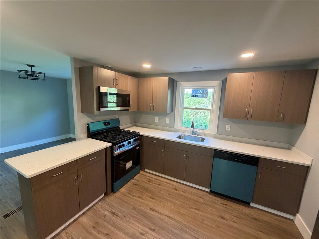 19 Springridge Road Bath, PA 18014 - Photo 8 of 29 Warm wood flooring pairs with clean countertops in this contemporary open-concept kitchen.