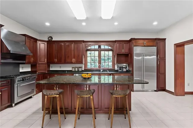a kitchen with stainless steel appliances granite countertop a stove refrigerator and cabinets