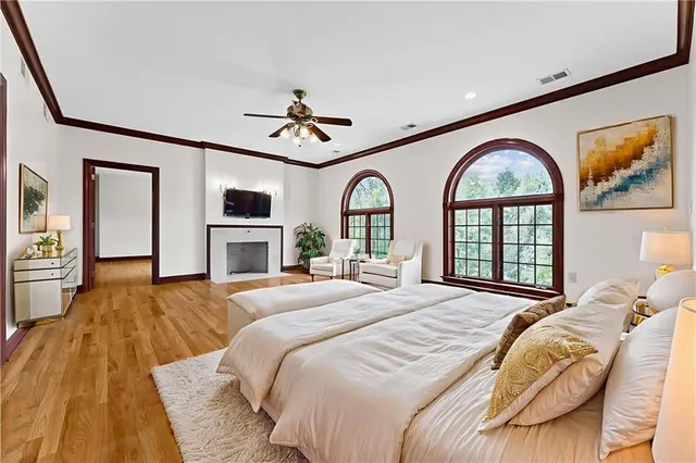 a view of empty room with wooden floor and fan