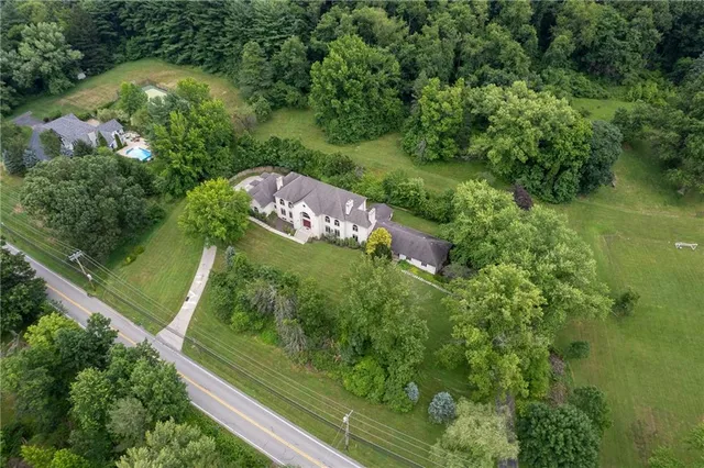 an aerial view of residential house with outdoor space and trees around