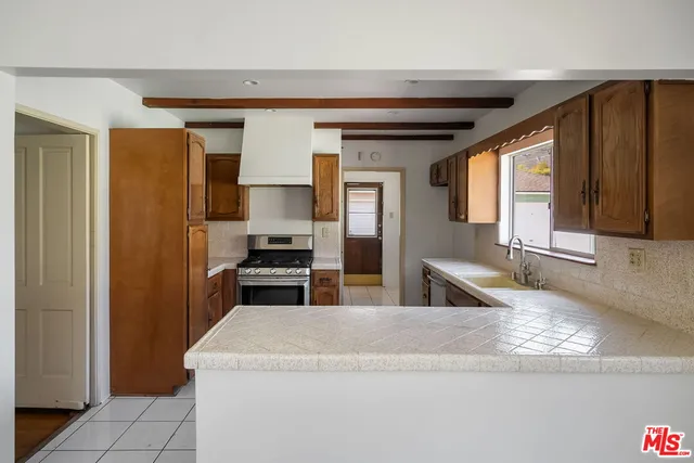 a kitchen with stainless steel appliances granite countertop a sink a stove and a refrigerator