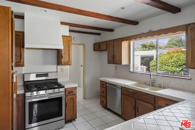 a kitchen with stainless steel appliances granite countertop a sink stove and cabinets