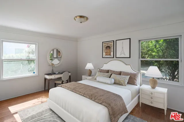 a bedroom with bed and a large window