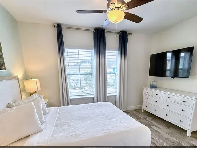 a bedroom with a bed and a flat tv screen on dresser