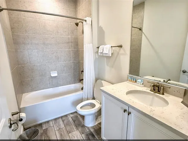 a bathroom with a granite countertop sink toilet a mirror and shower