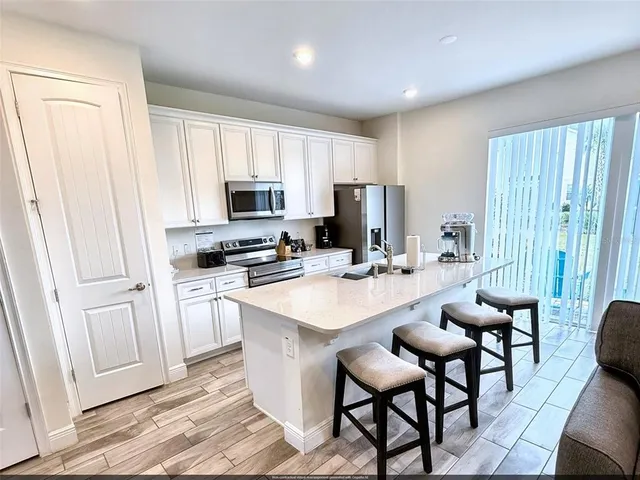 a kitchen with sink a microwave and refrigerator