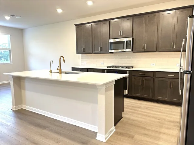 a kitchen with stainless steel appliances granite countertop a sink stove and microwave