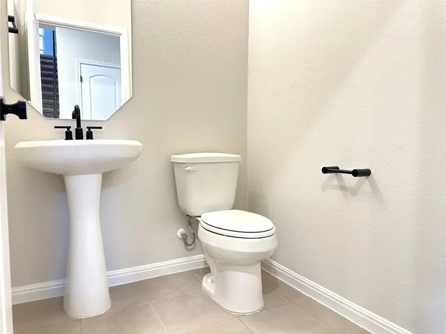 a bathroom with a sink toilet and a mirror