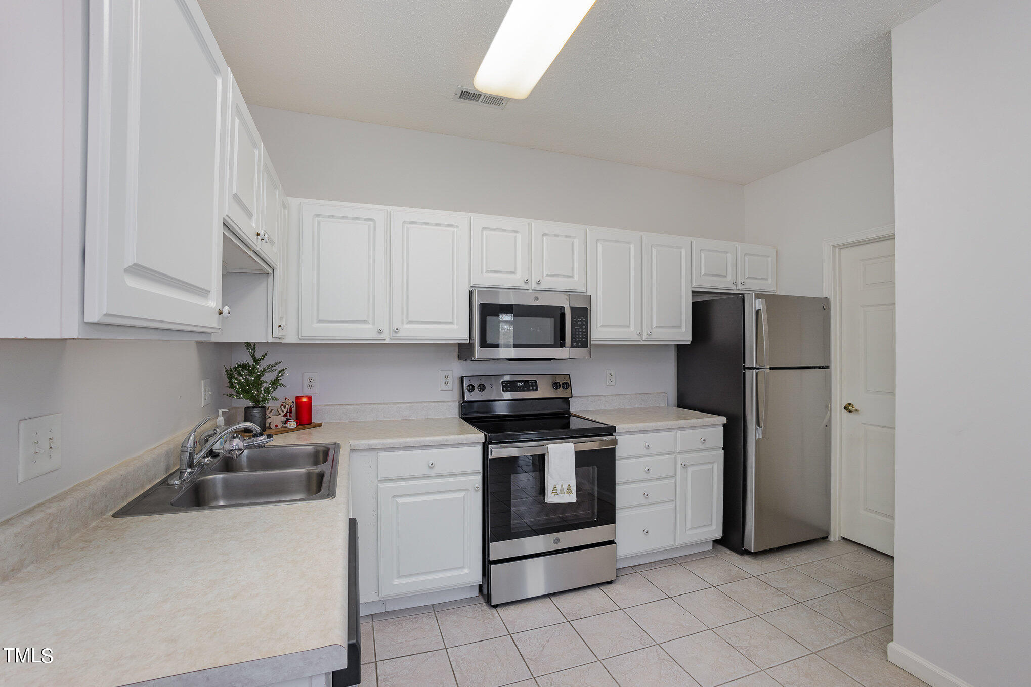 2500 Friedland Place, Unit 302 Raleigh, NC 27617 - Photo 4 of 15 a kitchen with white cabinets and stainless steel appliances
