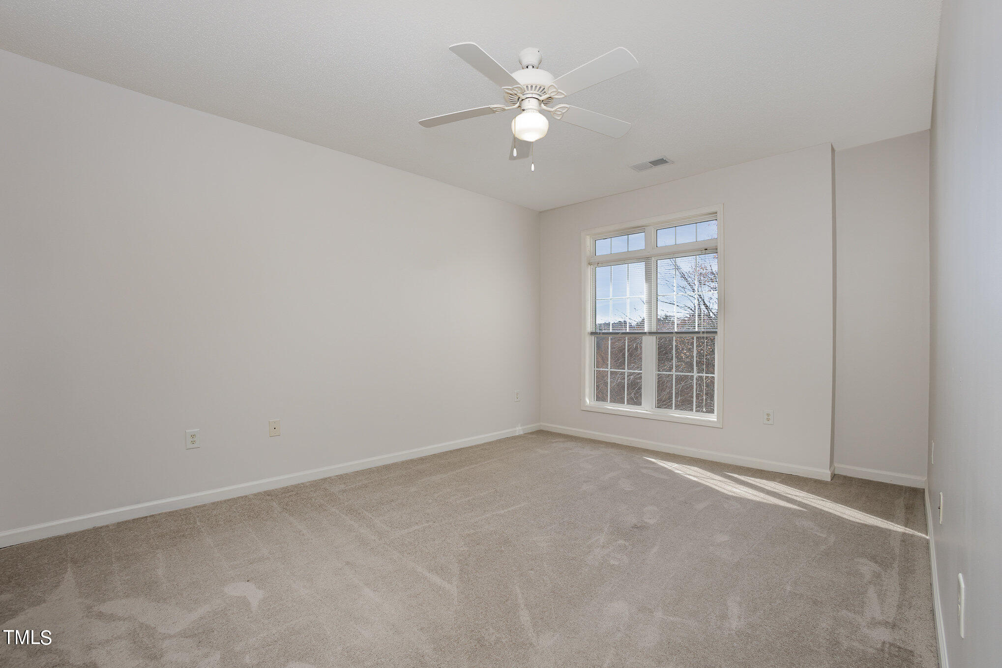 2500 Friedland Place, Unit 302 Raleigh, NC 27617 - Photo 10 of 15 an empty room with chandelier fan and windows
