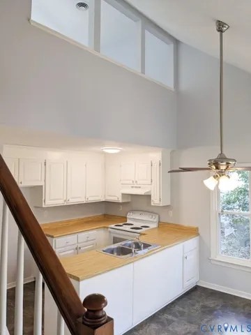 a kitchen with a stove a window and cabinets