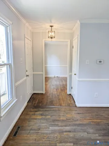 a view of empty room with wooden floor and window