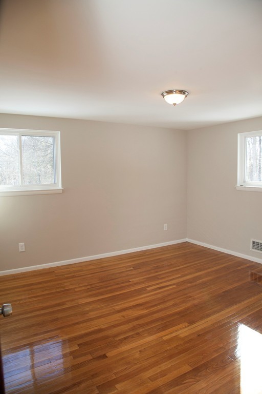 14 McAdams Road Framingham, MA 01701 - Photo 13 of 15 a view of an empty room with wooden floor and a window