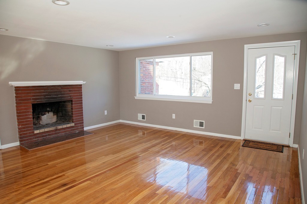 14 McAdams Road Framingham, MA 01701 - Photo 5 of 15 an empty room with wooden floor fireplace and windows