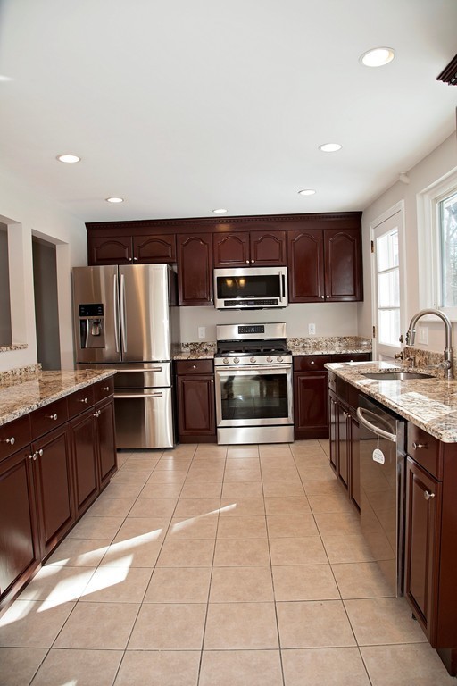 14 McAdams Road Framingham, MA 01701 - Photo 7 of 15 a kitchen with stainless steel appliances granite countertop a stove top oven a sink dishwasher a refrigerator and a oven