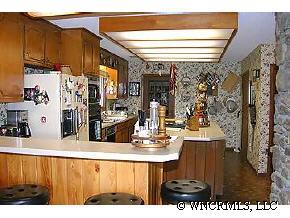 544 Brown Ridge Road Maggie Valley, NC 28751 - Photo 5 of 12 a view of kitchen island with stainless steel appliances kitchen island granite countertop a refrigerator and a stove
