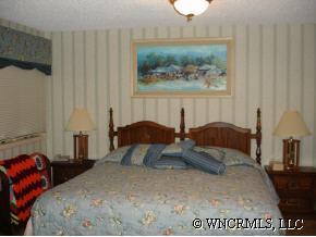 544 Brown Ridge Road Maggie Valley, NC 28751 - Photo 8 of 12 a bedroom with a bed and a painting on the wall