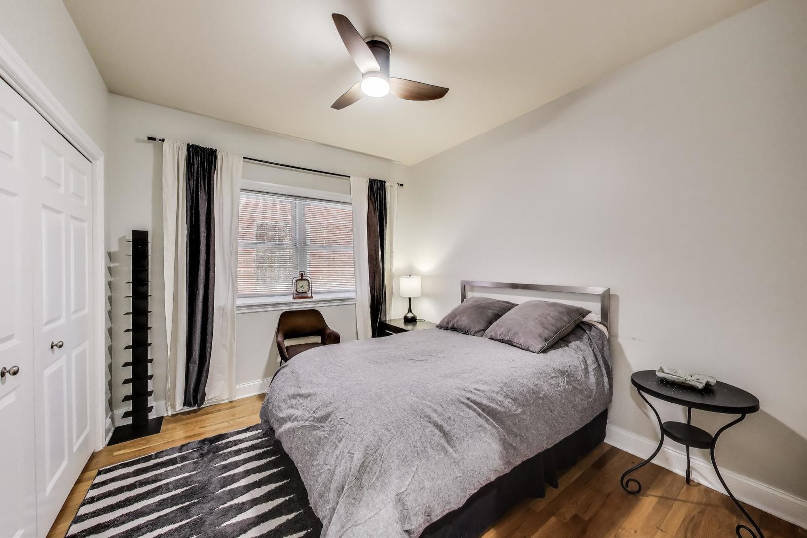 1035 West Taylor Street, Unit 1 Chicago, IL 60607 - Photo 11 of 22 a bedroom with a bed and a chandelier