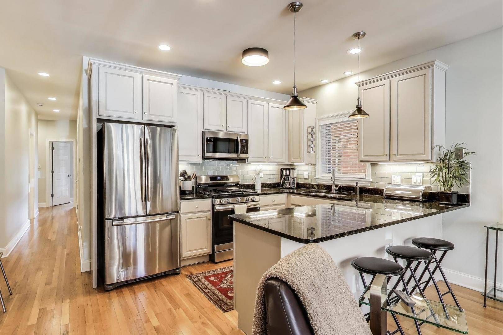 1035 West Taylor Street, Unit 1 Chicago, IL 60607 - Photo 4 of 22 a kitchen with kitchen island white cabinets stainless steel appliances a sink and a refrigerator