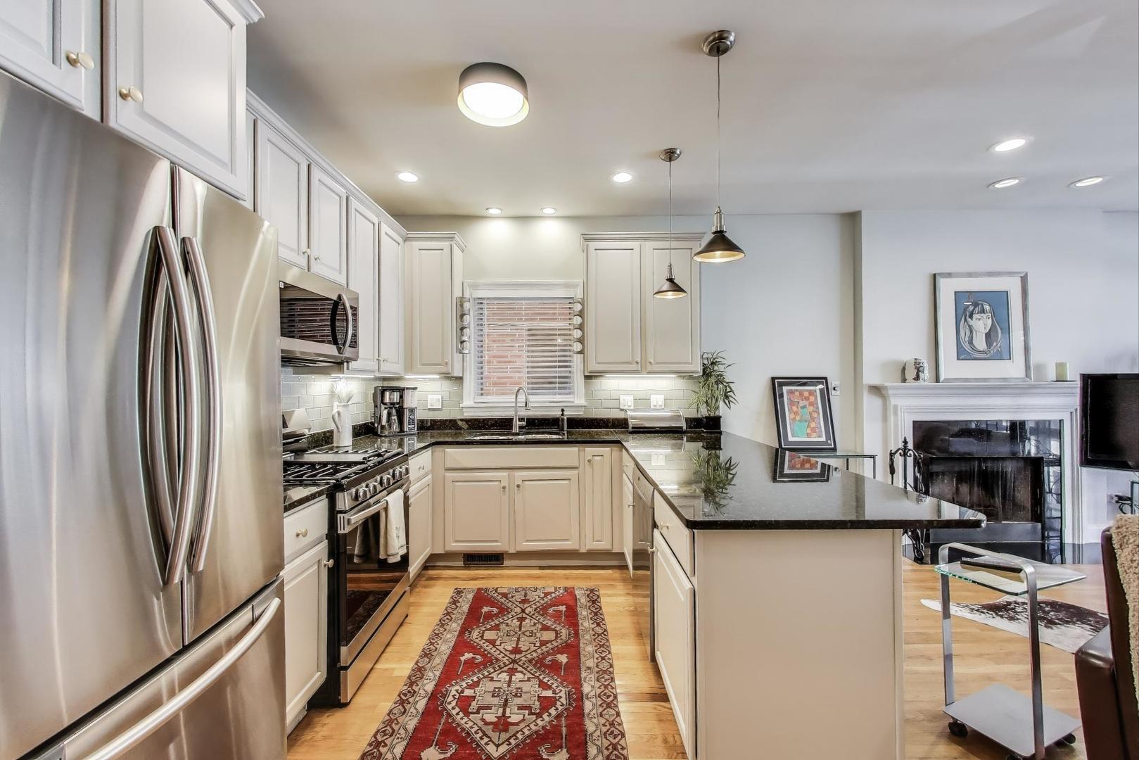 1035 West Taylor Street, Unit 1 Chicago, IL 60607 - Photo 5 of 22 a kitchen with stainless steel appliances granite countertop a refrigerator a stove microwave and sink