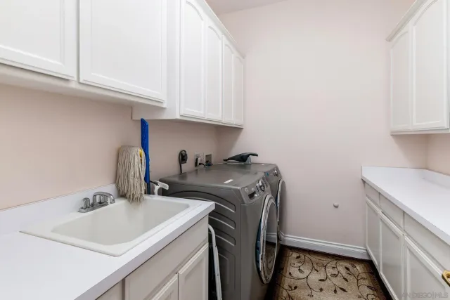 a utility room with sink dryer and washer