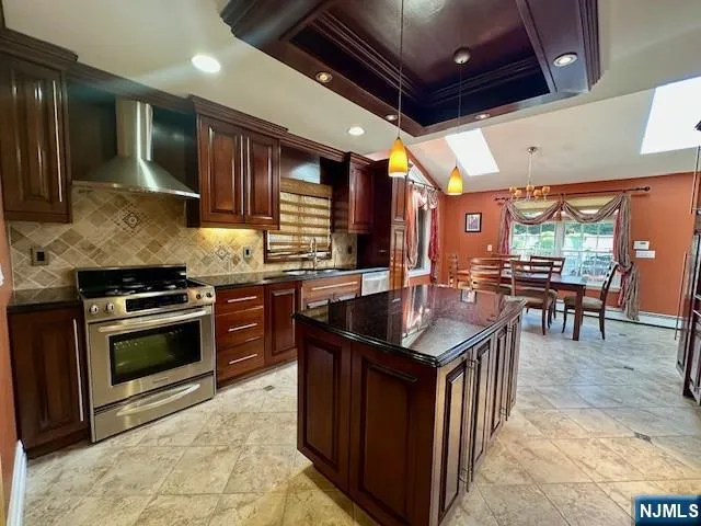 a kitchen with stainless steel appliances granite countertop a stove a sink and a refrigerator