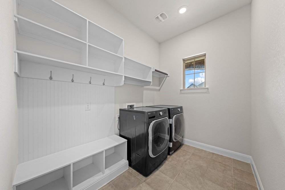 4208 Brean Down Road Pflugerville, TX 78660 - Photo 27 of 31 Functional tile flooring and abundant built-in shelving define this organized laundry space.