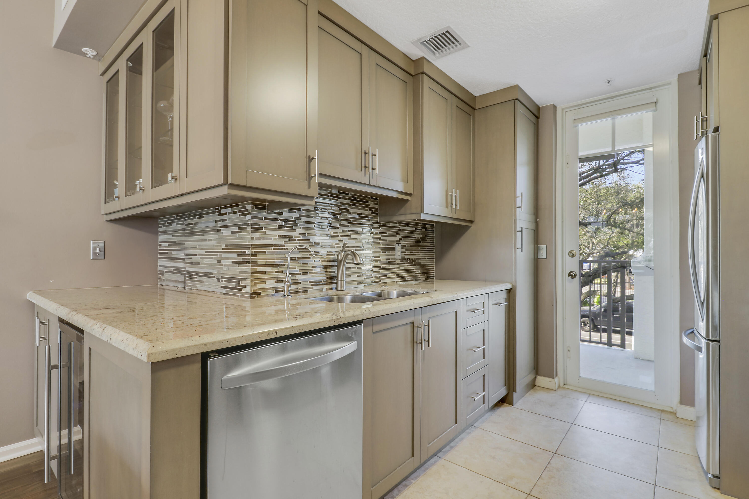 1152 University Boulevard, Unit 22 Jupiter, FL 33458 - Photo 11 of 24 a kitchen with stainless steel appliances granite countertop a sink and dishwasher with white cabinets