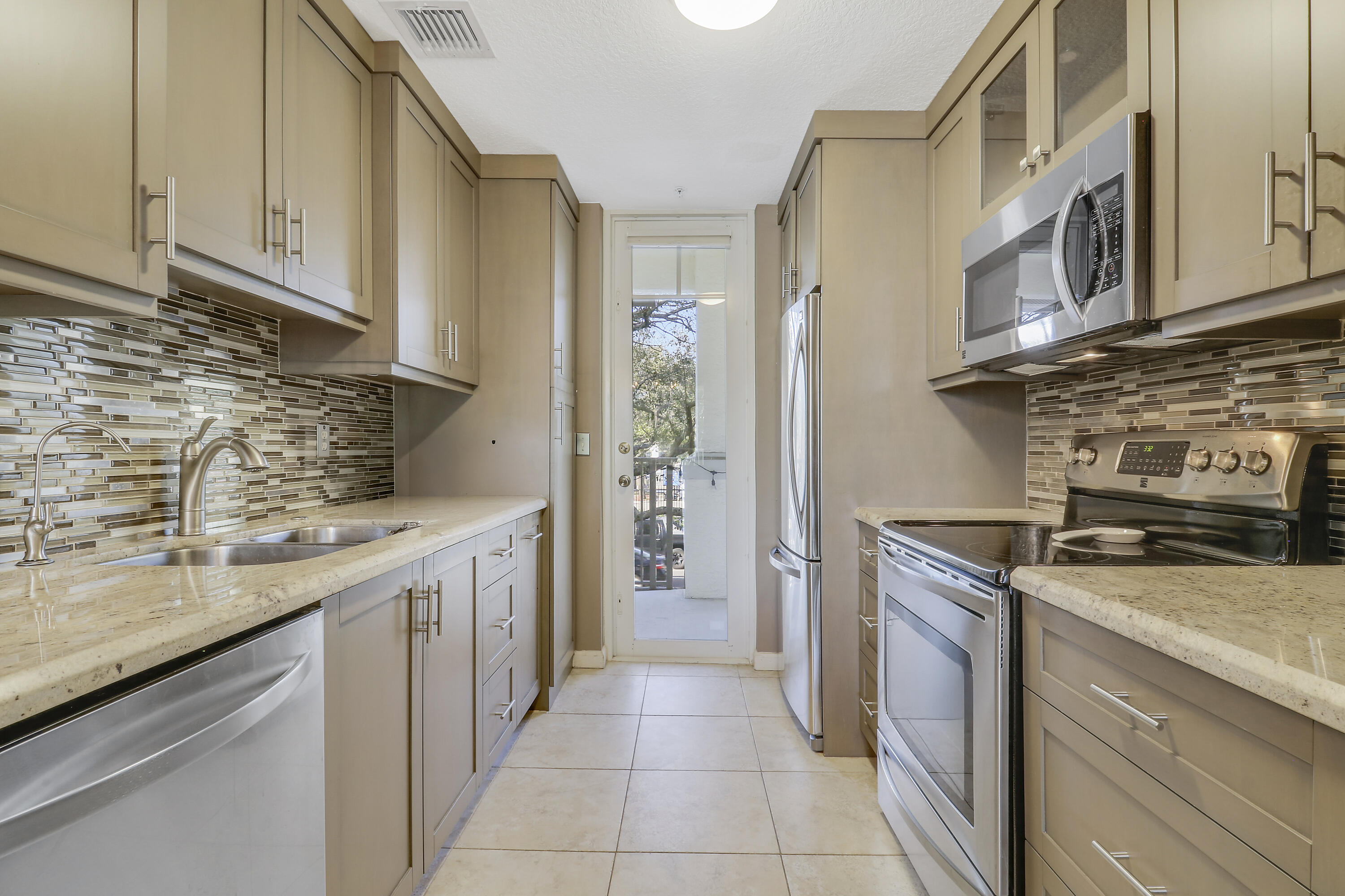 1152 University Boulevard, Unit 22 Jupiter, FL 33458 - Photo 12 of 24 a kitchen with stainless steel appliances granite countertop a stove and a sink