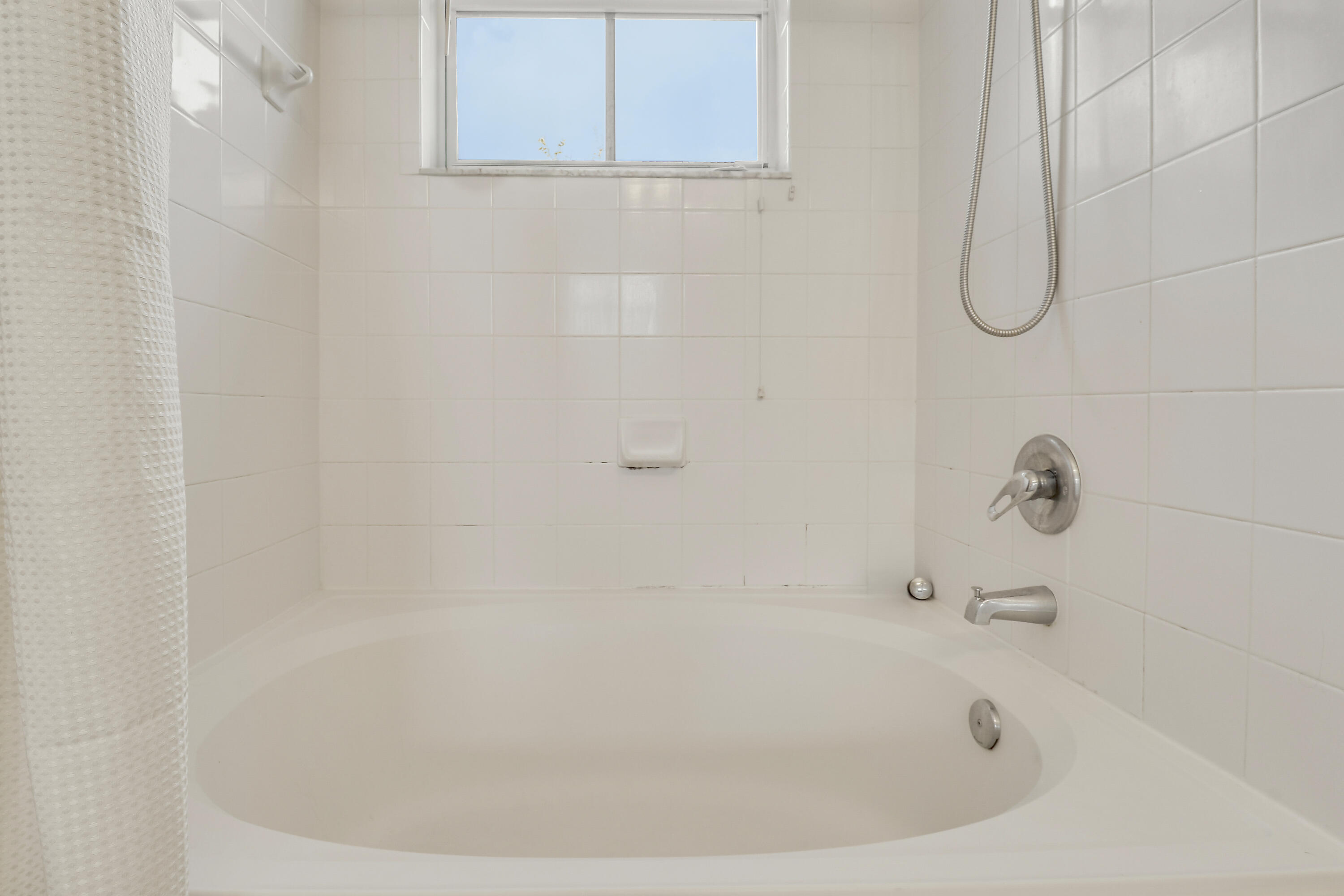 1152 University Boulevard, Unit 22 Jupiter, FL 33458 - Photo 18 of 24 a bathroom with a white bath tub and a shower