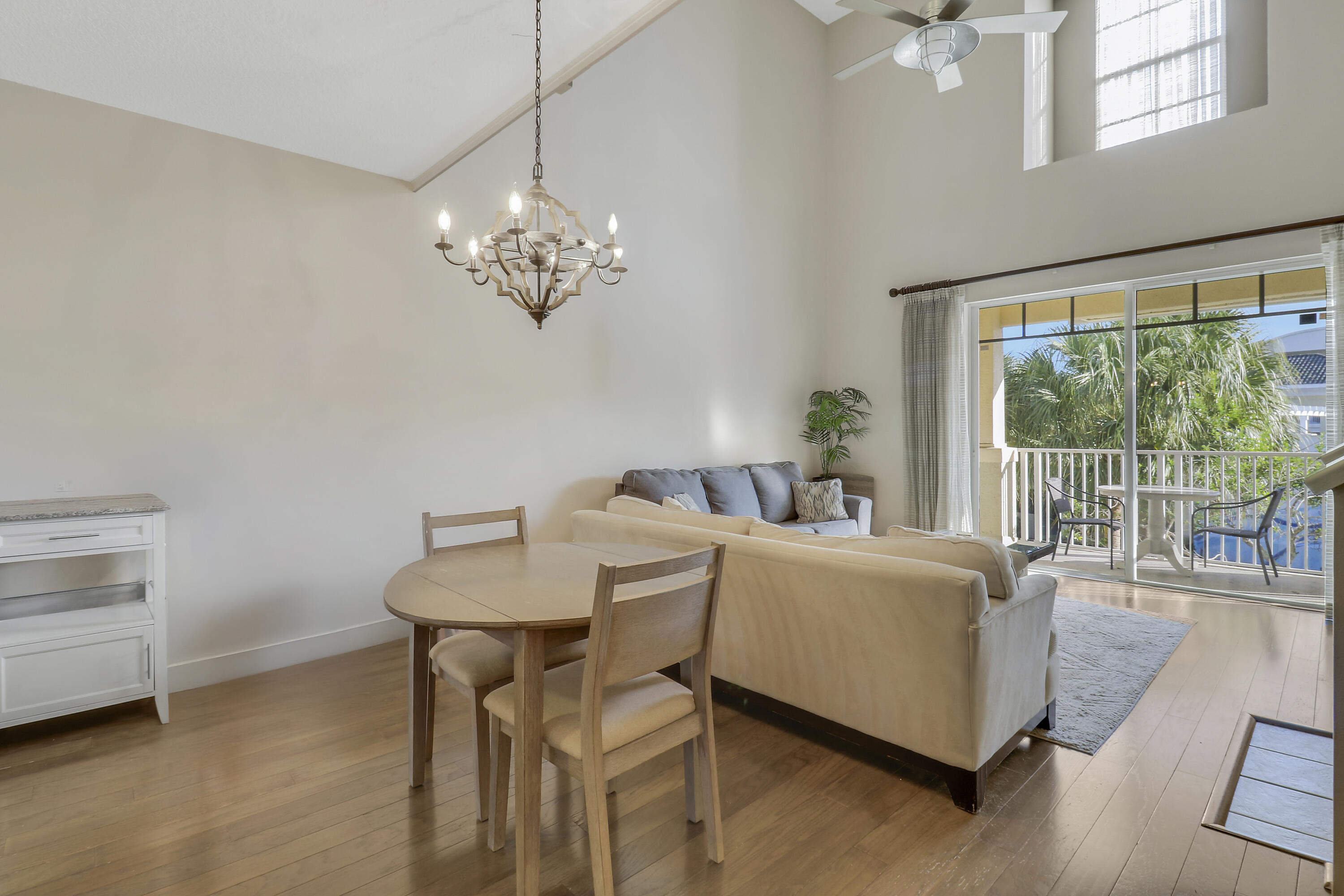 1152 University Boulevard, Unit 22 Jupiter, FL 33458 - Photo 7 of 24 a living room with furniture and a chandelier