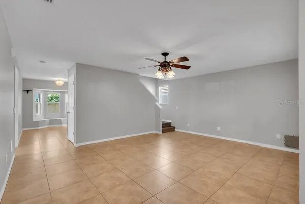 a view of an empty room with a chandelier fan