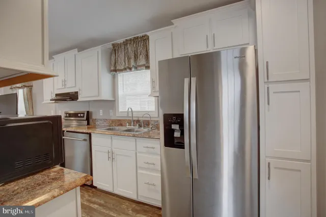 a kitchen with stainless steel appliances granite countertop a refrigerator and a stove top oven
