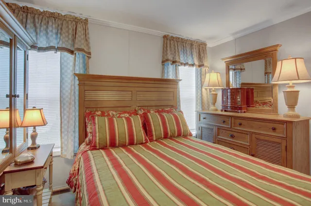 a bedroom with a bed and dresser with mirror