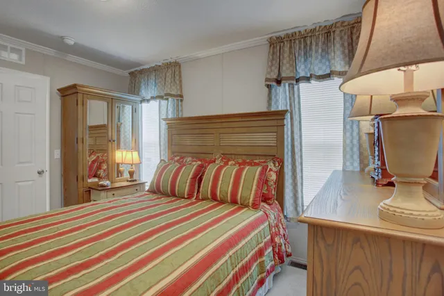 a bedroom with a bed and a flat tv screen on dresser