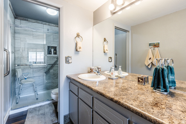 1470 Redwood Tree Street St. George, UT 84790 - Photo 20 of 53 Bathroom featuring a dual vanity with integrated sinks, a patterned countertop, and gray cabinetry