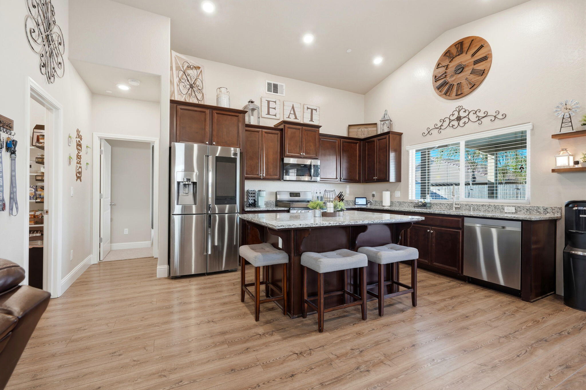 756 Strada Street Lemoore, CA 93245 - Photo 12 of 53 a kitchen with stainless steel appliances a table chairs refrigerator and cabinets