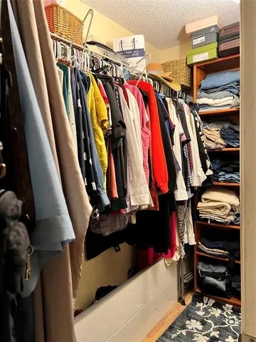 a view of walk in closet with clothes and shoes