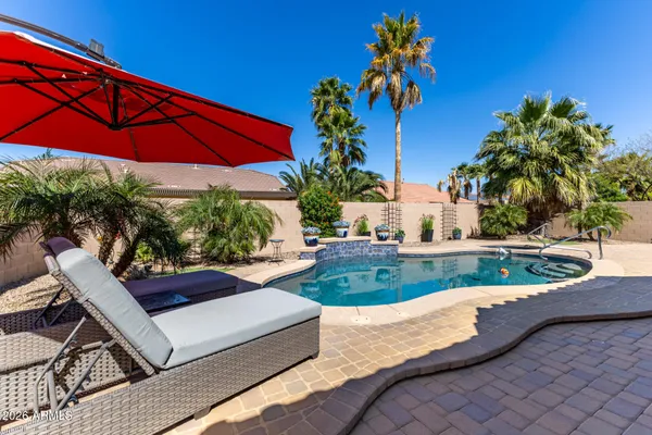 a view of a yard with furniture and a table under an umbrella