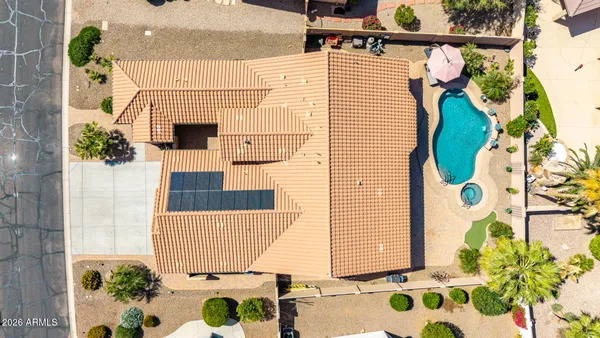 an aerial view of a house with a yard and a large tree