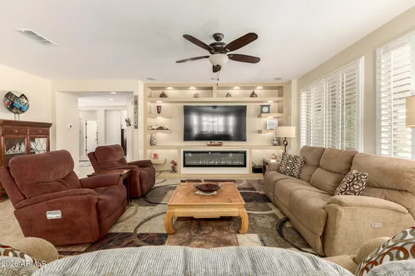 a living room with furniture a flat screen tv a rug and a window