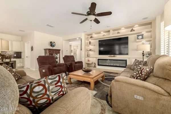 a living room with furniture a flat screen tv and a large window