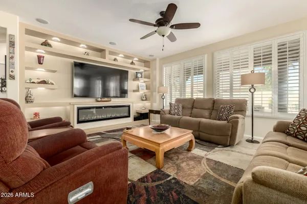 a living room with furniture a large window and a chandelier