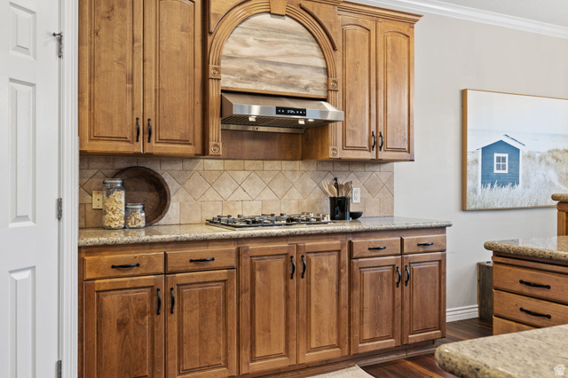6208 West Bull River Road Highland, UT 84003 - Photo 24 of 90 Kitchen featuring wood-finish cabinetry, light-toned granite countertops, and a tiled backsplash