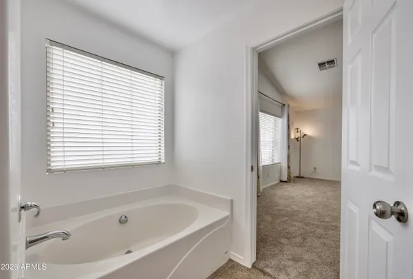 a spacious bathroom with a granite countertop sink a mirror and a bathtub with shower