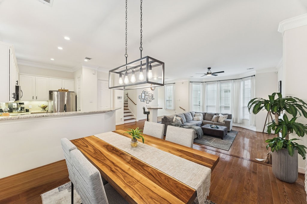 5737 Kansas Street Houston, TX 77007 - Photo 22 of 47 a view of a dining room and livingroom with furniture wooden floor a chandelier