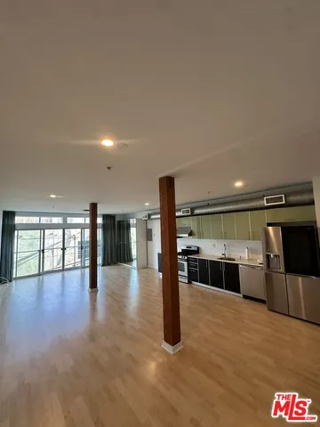 a kitchen with stainless steel appliances a refrigerator and wooden floor