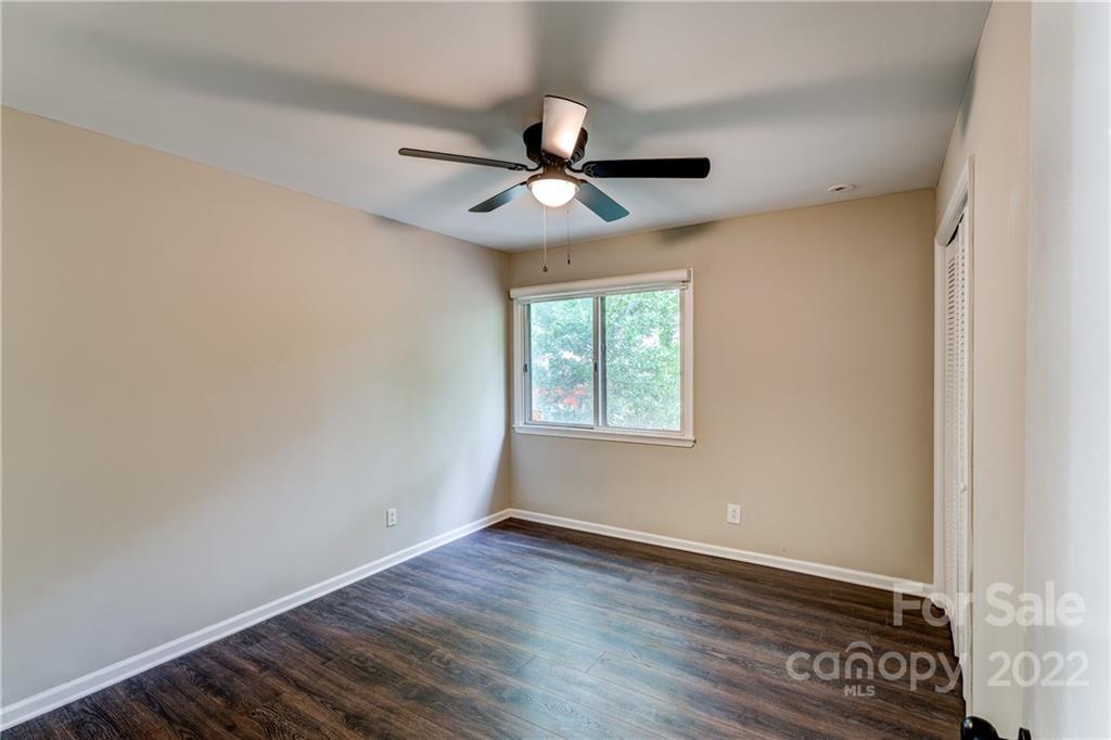 3088 Point Clear Drive Tega Cay, SC 29708 - Photo 11 of 32 an empty room with wooden floor ceiling fan and windows