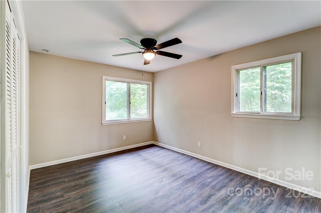 3088 Point Clear Drive Tega Cay, SC 29708 - Photo 13 of 32 an empty room with wooden floor ceiling fan and windows
