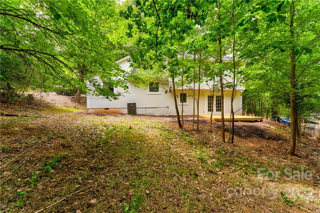 3088 Point Clear Drive Tega Cay, SC 29708 - Photo 24 of 32 a backyard of a house with lots of plants and large trees
